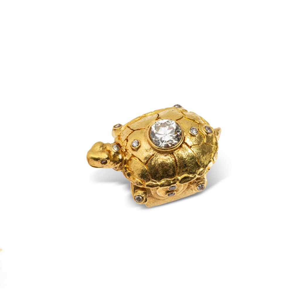 P0546-0001 Adjugé Bague en or jaune amati 22 k (poinçonné 18k, 750 millièmes) figurant une tortue surmontée en serti clos d'un diamant demi taille de 4,26 carats, et agrémentée de 12 autres diamants plus petits. Signée. Diam. pierre : 10.44-10.61 x 6.20 mm Poids brut : 62,3 g
