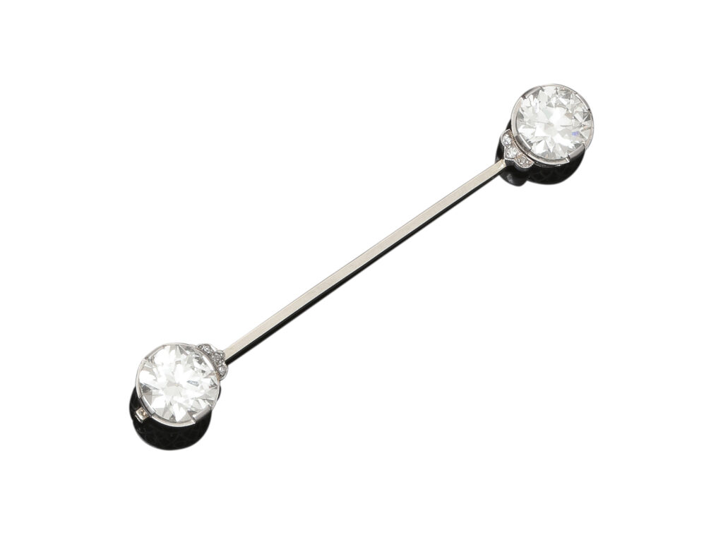 Adjugé 12 000 €_Broche barrette en or gris 18k (750 millièmes) et platine (950 millièmes) sertie à chaque extremité d'un diamant taille ancienne entre 2,80 et 2,90 carats