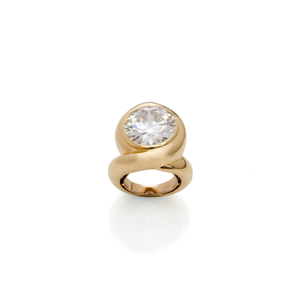 Adjugé 53 000 €_René BOIVIN_Bague en or jaune (750 millièmes) ornée d’un diamant taille brillant de 10,96 carats en serti clos, sur un anneau décentré formant un entrelac. Vers 1970. Signée "René Boivin", poinçon de maître