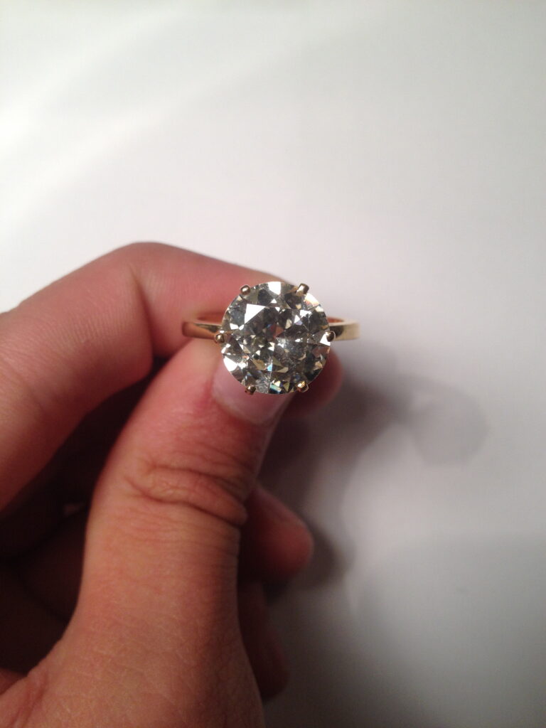 C1403-0033_Adjugé 19 000_Solitaire en or jaune 18 k. Il est orné d'un diamant demi-taille d'environ 4,60 cts. Tour de doigt 56. Poids brut: 5,2 g..jpg