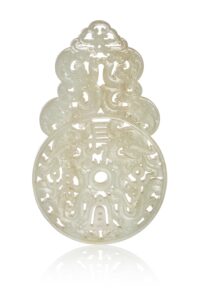 N0456-0012_CHINE, XVIIIe siècle Élément en jade céladon À décor sculpté et ajouré prenant la forme d'un disque bi comprenant quatre phénix stylisés autour d'un caractère, la partie supérieure ornée de dragons stylisés. La pierre aux tons céladon légèrement infusés de rouille. Hauteur : 12,7 cm Largeur : 7,7 cm Adjugé 28 000 €