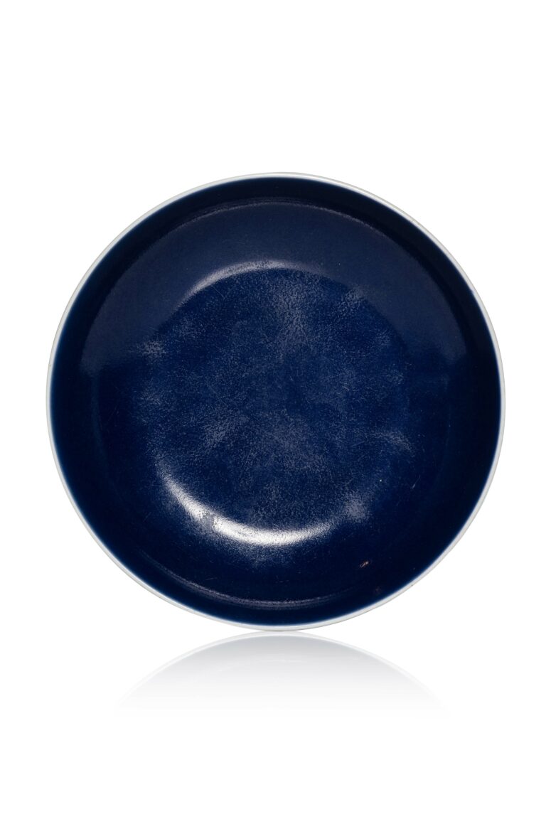 N4230-0011_CHINE, Marque et époque Qianlong, XVIIIe siècle, Coupelle en porcelaine,Montée sur un court pied, la paroi circulaire, revêtue sur l'ensemble d'une couverte monochrome bleu sacrificiel dit "ji lan". Une marque Qianlong à six caractères en bleu de cobalt sous la base. Hauteur : 4 cm Diamètre : 16 cm Adjugé 15 000 €