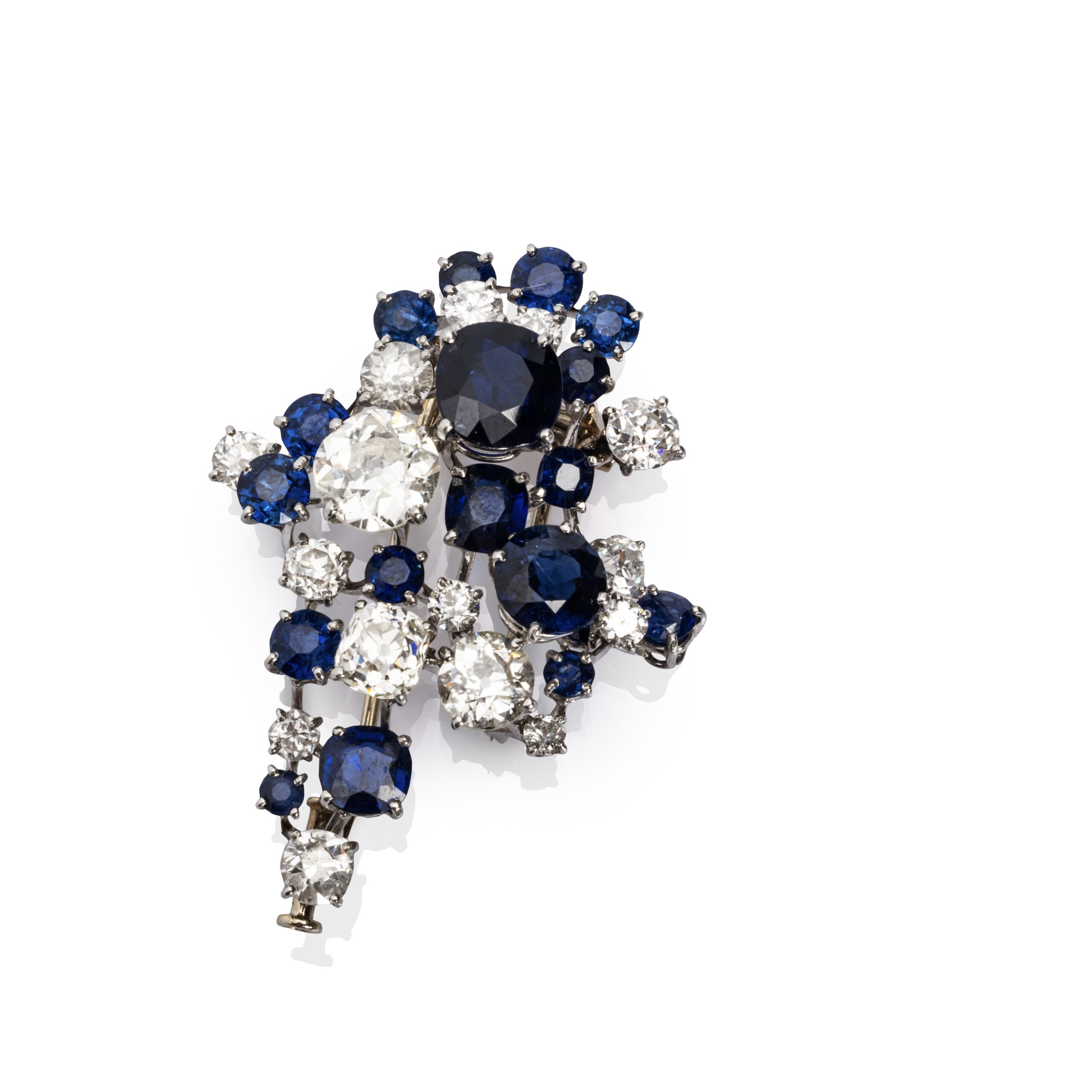 Expertise Clip diamants et saphirs - Broche en platine (950 millièmes) et or gris 18k (750 millièmes) sertie d'une constellation de saphirs et diamants ronds et coussins. Travail français. Poids brut : 16,3 g. Haut.: 4,2 cm - Adjugé 3 600 €