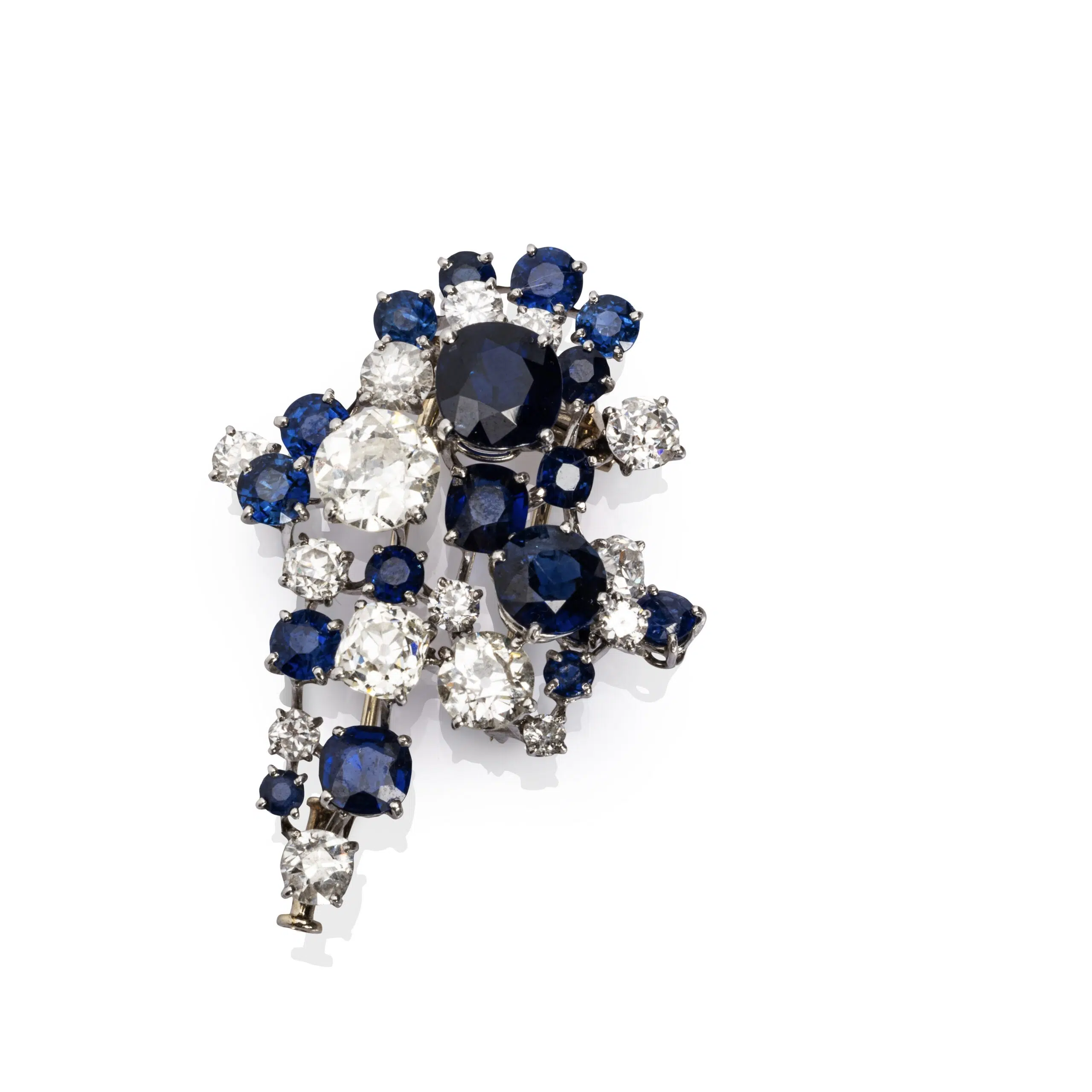 Expertise Clip diamants et saphirs - Broche en platine (950 millièmes) et or gris 18k (750 millièmes) sertie d'une constellation de saphirs et diamants ronds et coussins. Travail français. Poids brut : 16,3 g. Haut.: 4,2 cm - Adjugé 3 600 €