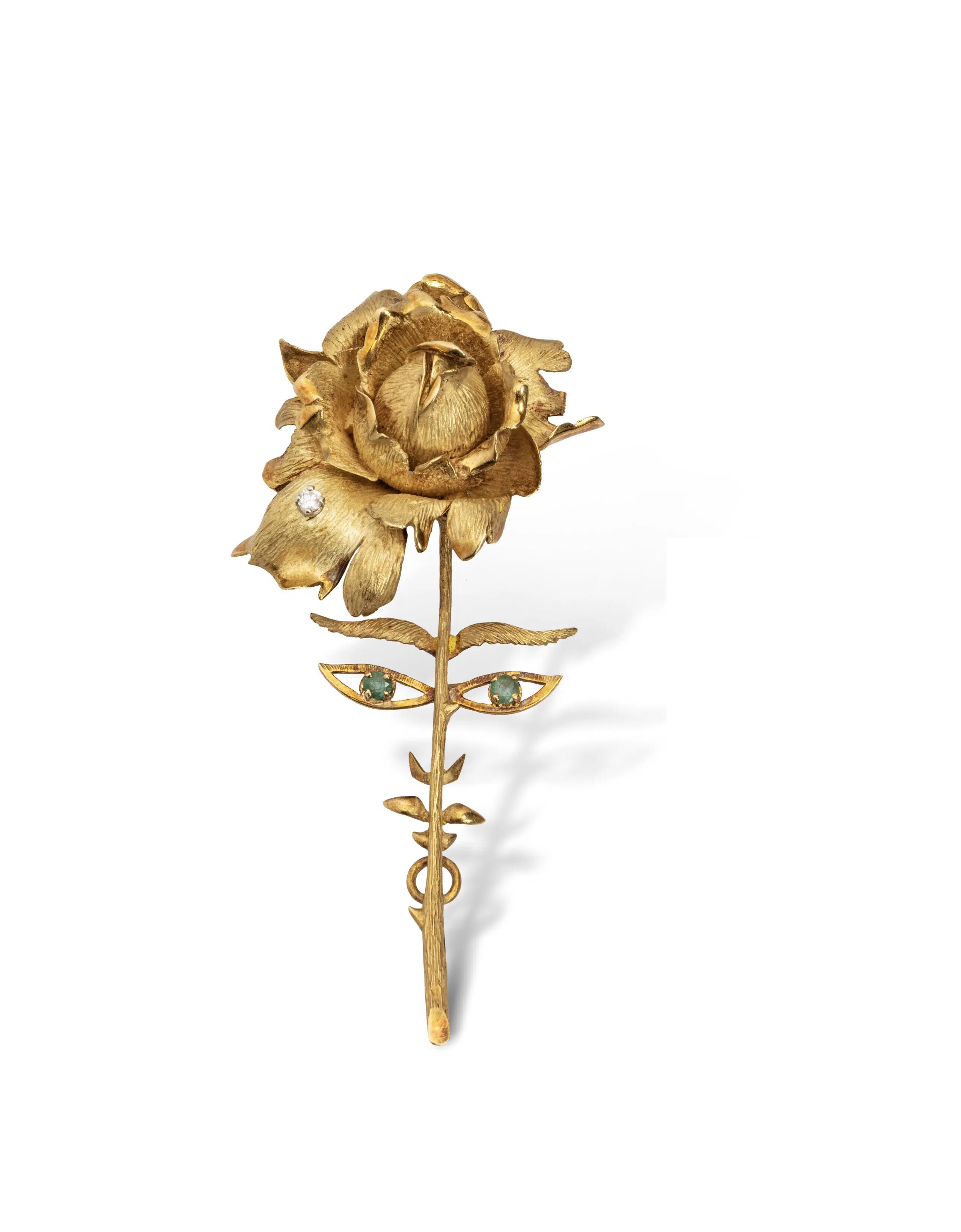 Expertise bijoux - Clip de revers en or jaune 18k (750 millièmes) figurant une rose agrémentée d'un petit diamant, le yeux soulignés de deux émeraudes. Signé JC, poinçon de maître d'Edouard Richard. Certificat d'authenticité. Poids brut : : 26,1 g. Haut.: 8,5 cm - Adjugé 3 800 €