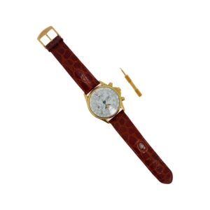Montre chronographe - Montre chronographe en or jaune 18K (750°/°°) boitier circulaire, cadran à fond blanc, chiffres arabes, guichet date à 12H; le bracelet en cuir; boucle ardillon en métal doré. Poids brut: 97,1 gr. L: 24 cm env. On y joint une clé de montre en métal doré.