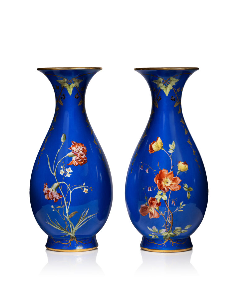 Sèvres - Description : Paire de vases balustres dits “Bertin” de 2e grandeur en porcelaine dure, à fond bleu et décor naturaliste polychrome de fleurs, blanches sur une face et rouges de l’autre, alternées de frises de feuilles de lierre enlacées, large filet or sur les bords. Bon état, avec leurs doublures internes en tôle. Manufacture impériale de Sèvres, 1853. Marques au tampon vert “S. 52” de fabrication pour 1852, et marque au tampon rouge de décor à l’aigle impériale datée “S. 53” pour 1853. H. 53,5 x D. 19 cm. Adjugé 4 200 €