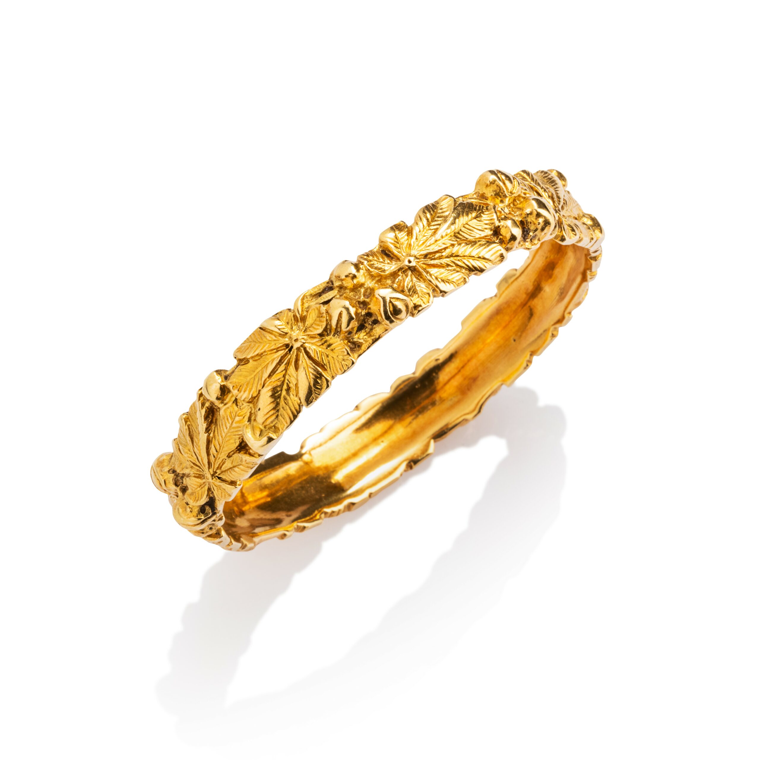 Adolphe CHRÉTIEN, Bracelet rigide en or jaune 18k (750 millièmes) à décor de fruits et feuillages en relief. Signé, numéroté. Poids : 65,8 g. Diam. interne : 19,5 cm, adjugé 5 200 €